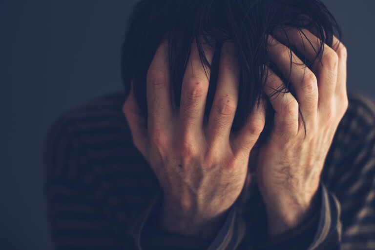 Hopeless drug addict holding his head